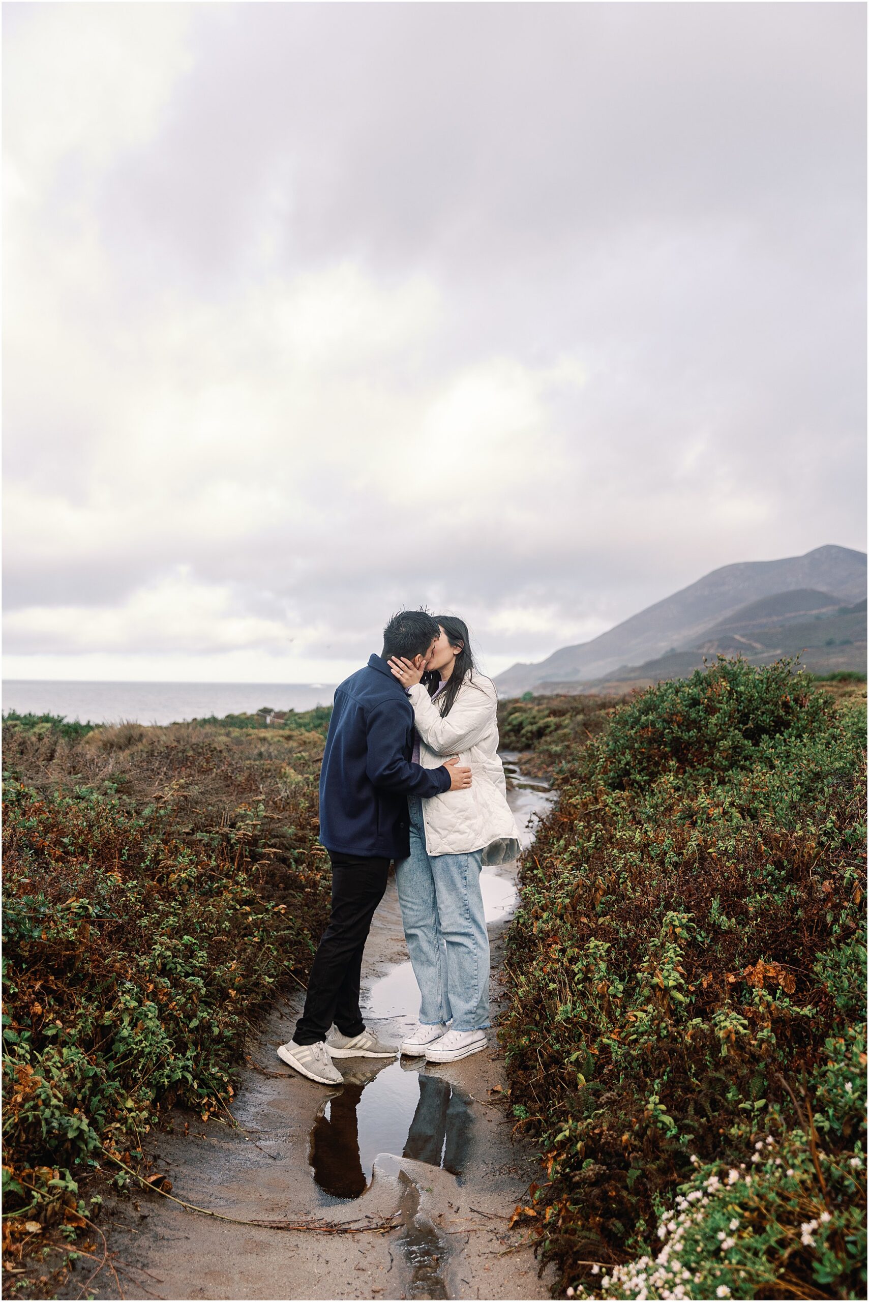 Emotional kiss during cliffside proposal in California.