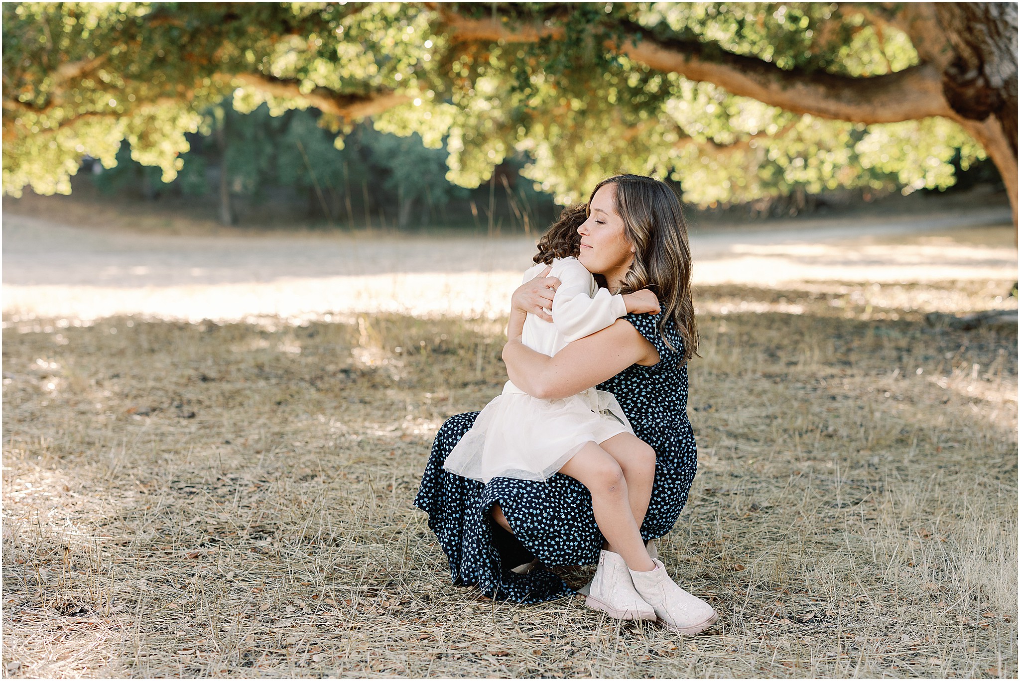 Mother holding daughter and enjoying a quiet moment during family photography session.