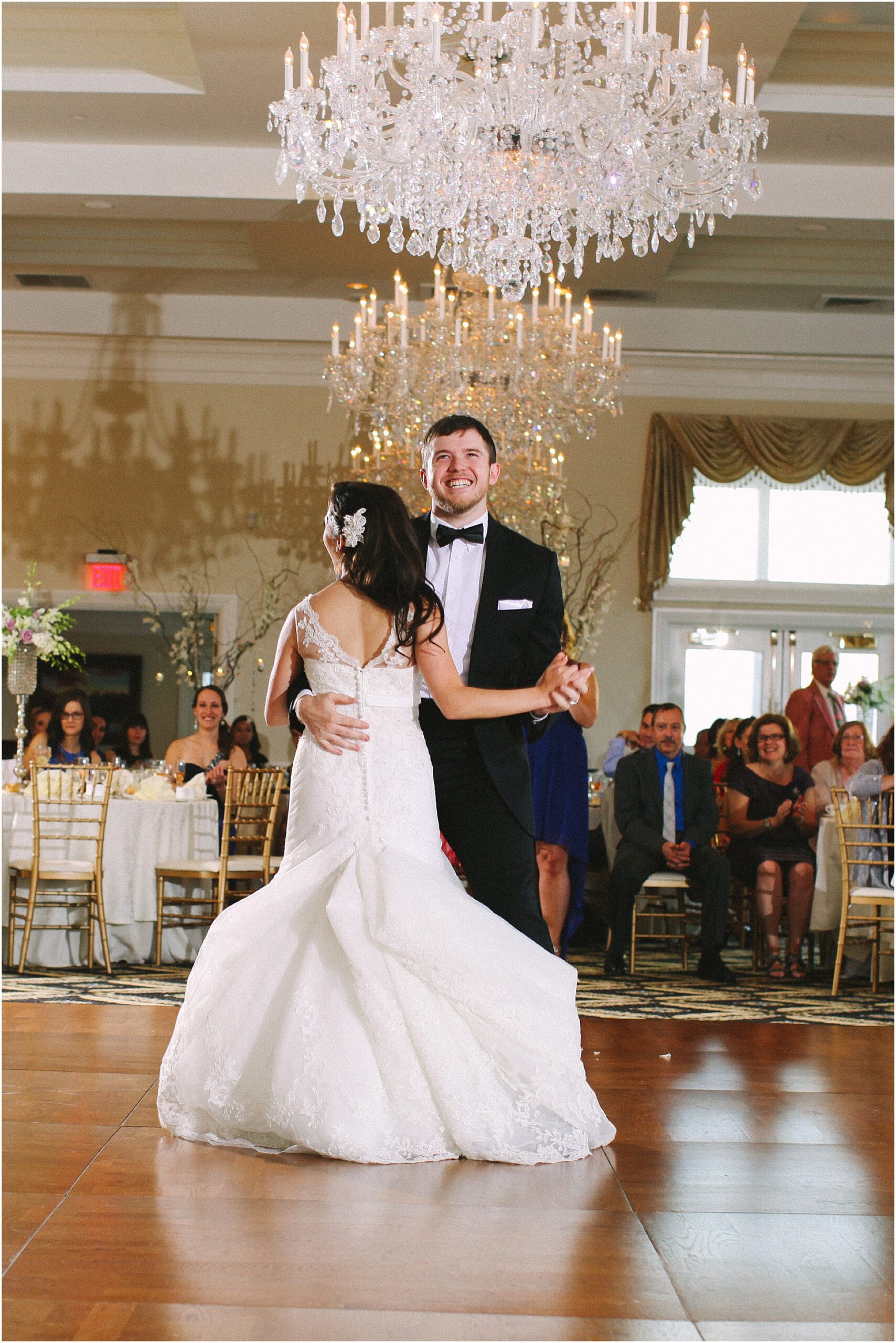 Bride and groom dancing beneath crystal chandeliers at a luxury Philadelphia wedding reception