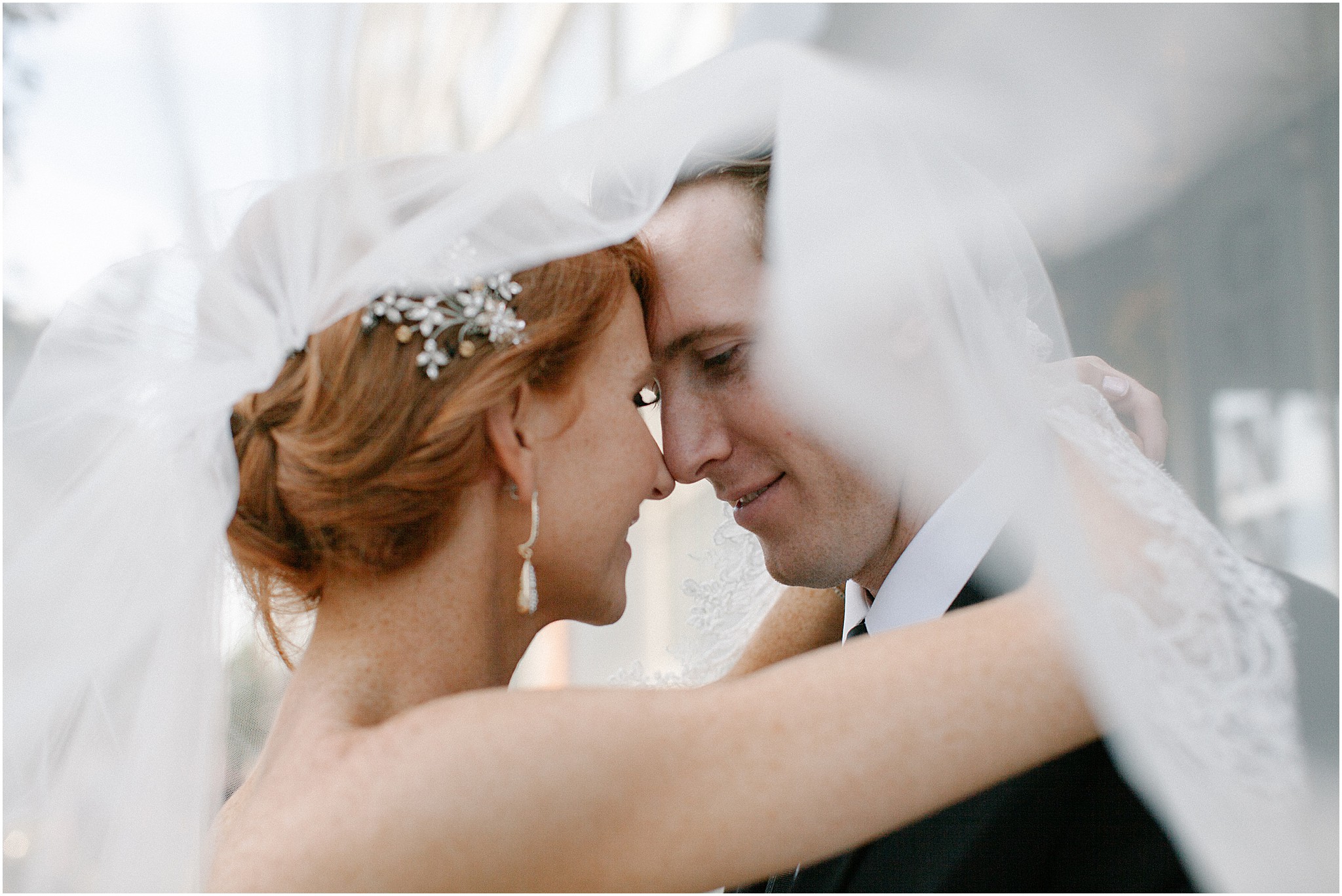 Bride and groom embracing under a veil during romantic Philadelphia wedding portrait.
