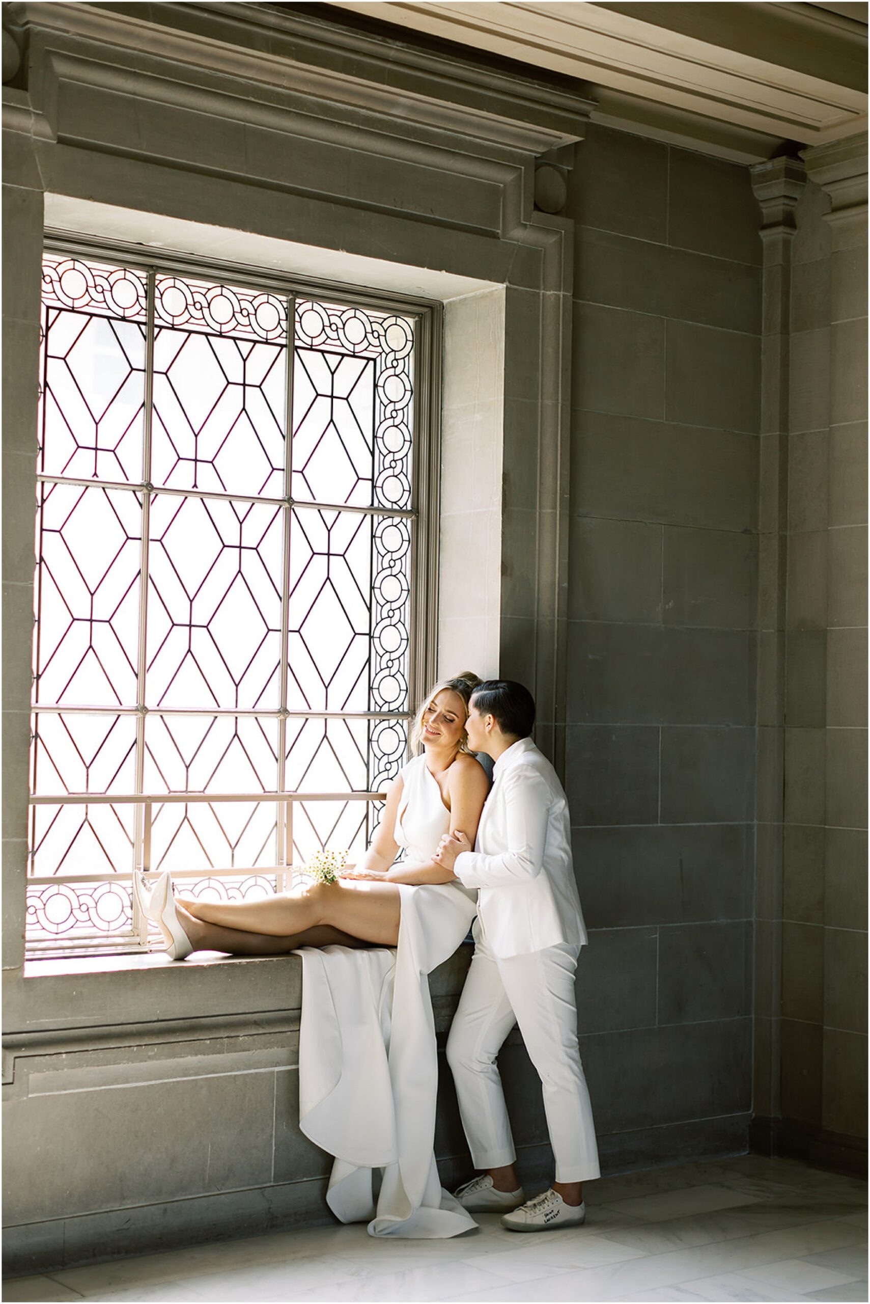 Couple embracing in soft window light inside City Hall