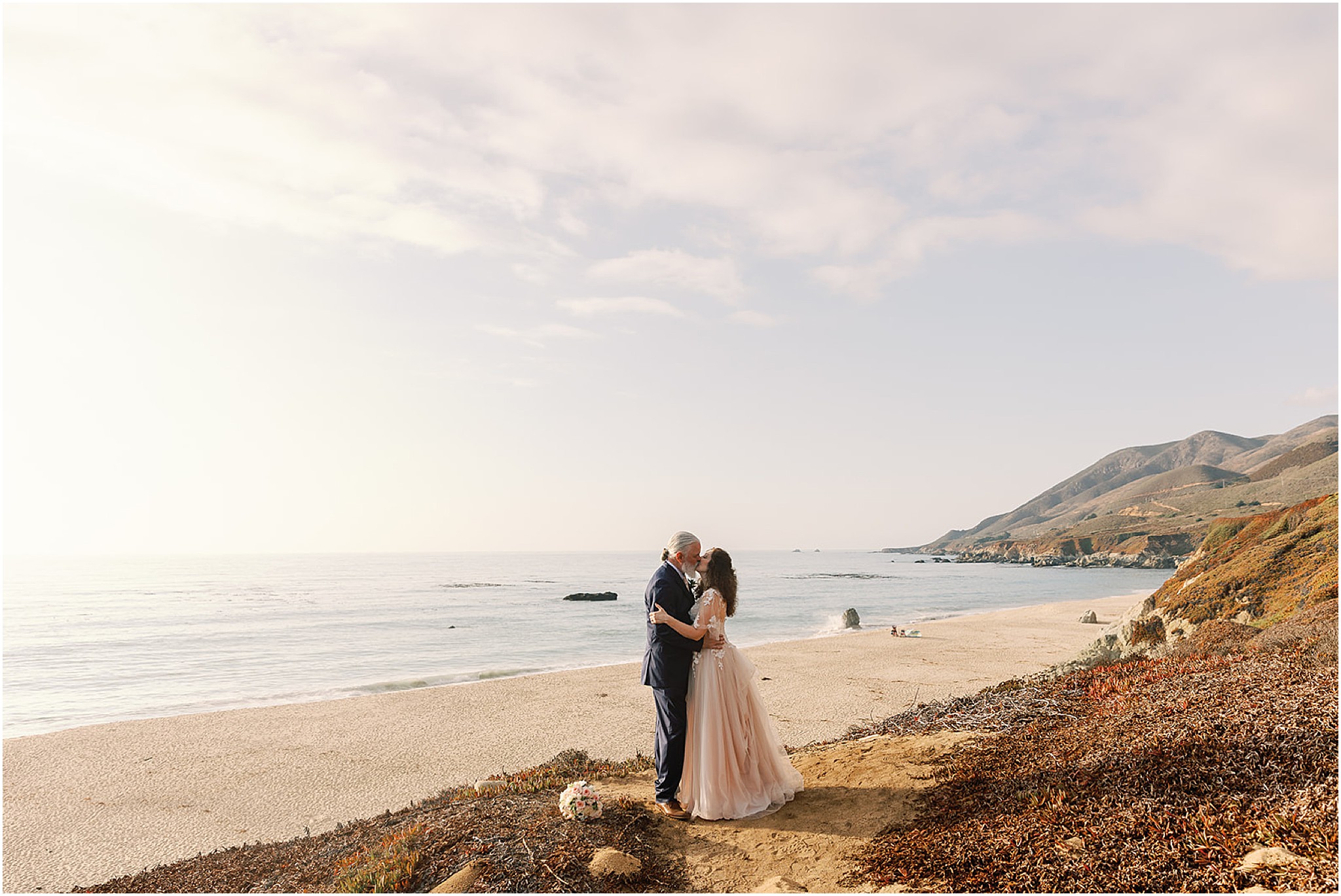 Wedding couple silhouetted against Big Sur sunset sky