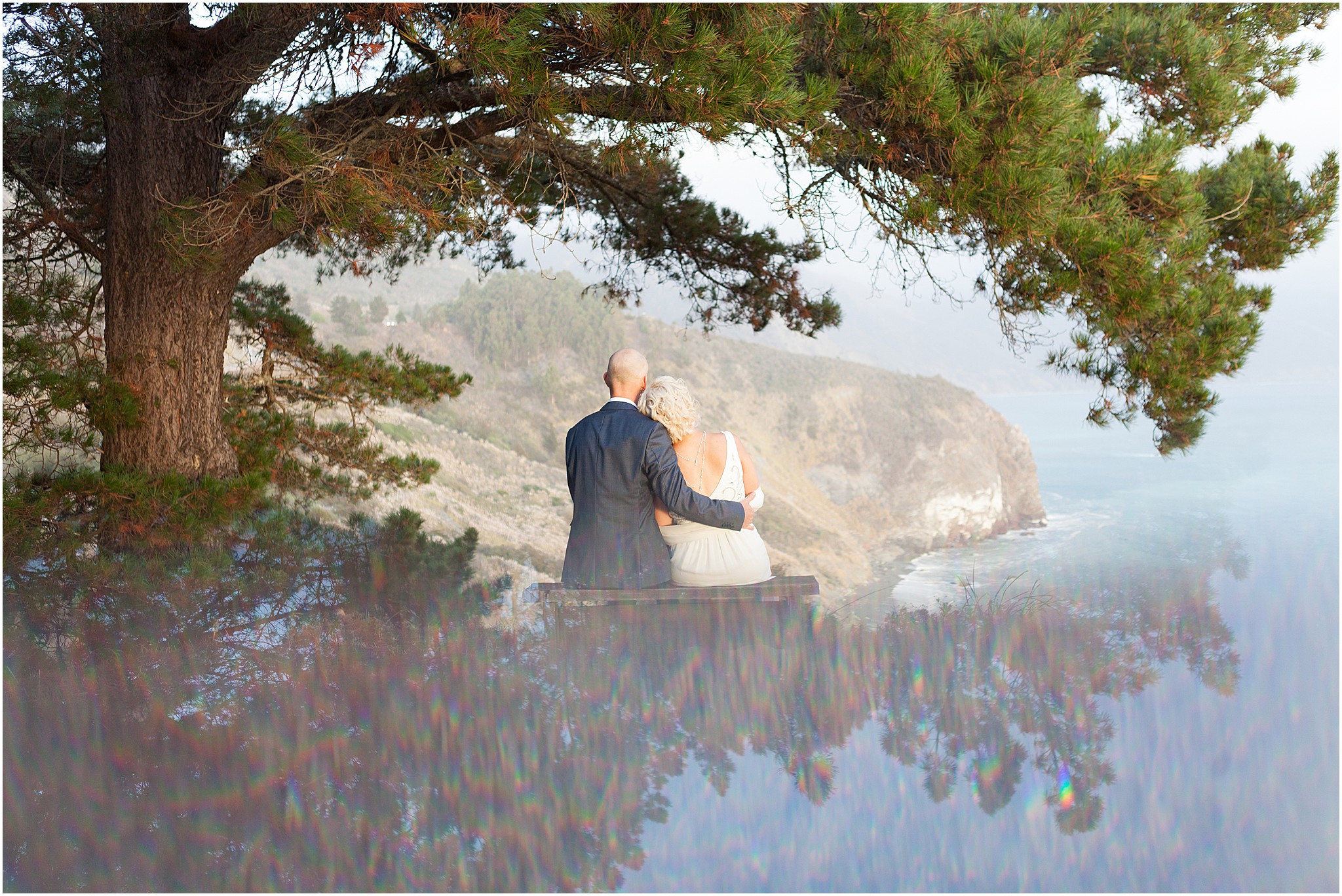 Couple embracing while overlooking Big Sur coastline.
