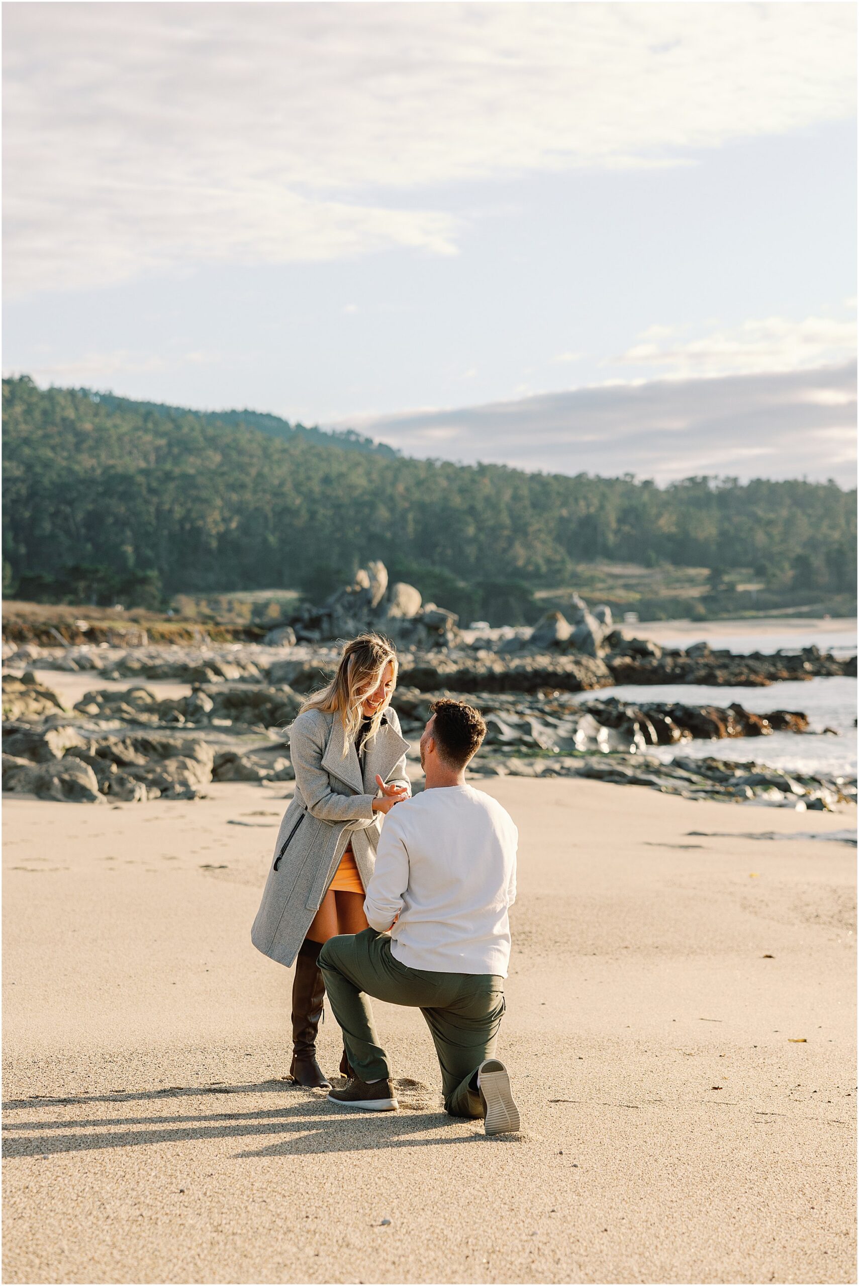 Camilla reacting as Bernardo gets down on one knee for a surprise beach proposal