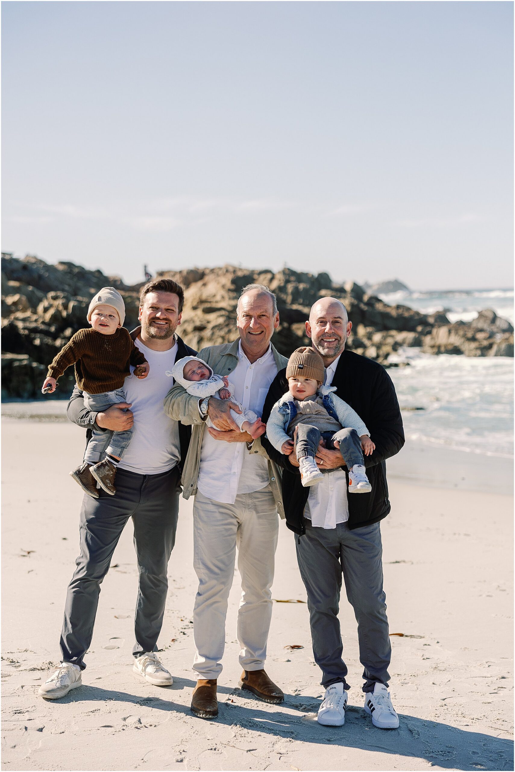 Grandfather and family members holding the youngest children during a Carmel beach portrait