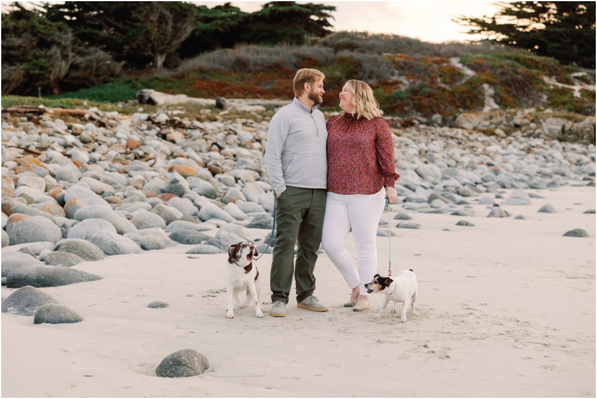 Couple standing with their two dogs during a relaxed coastal family photo session